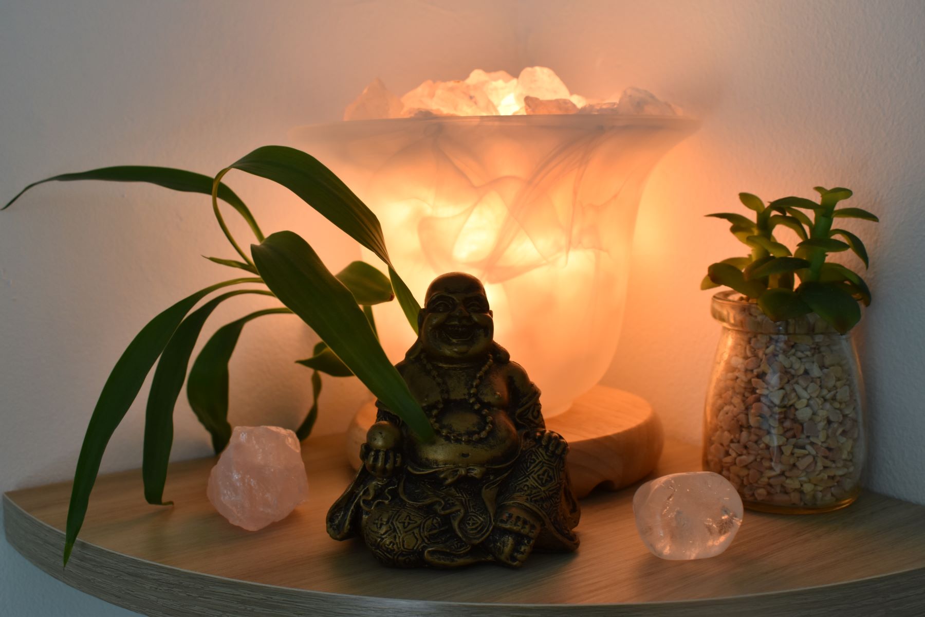 Photographie d'un buddah devant une lampe de sel.